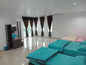 Batu LimaEMERALD VILLA HOMESTAY DUNGUN的一间带两张床和镜子的客厅