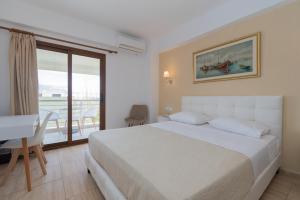 新马尔马拉斯Star Paradise Hotel的一间卧室配有一张床、一张书桌和一个窗户。