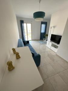 帕泰尔诺Casa Vacanze Le Tre Scimmiette的客厅配有白色桌子和蓝色沙发