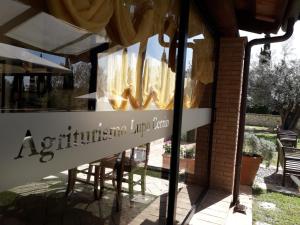 塔尔奎尼亚切利诺卢波农场乡村民宿的餐厅窗户,带椅子和标志
