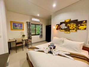 清莱บ้านกาญจน์ เชียงราย Baan Kan Chiang Rai的一间卧室配有一张床铺和一张桌子,还有一间用餐室