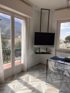 托尔博莱La Casa Verde Torbole的客厅配有平面电视和2扇窗户。