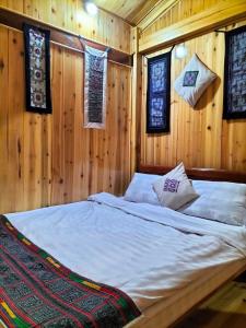 萨帕Sapa Shalom Homestay的卧室配有木墙和窗户。