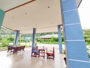 考索Khao Sok Backpacker Hostel的一个带桌椅的庭院和蓝色的墙壁