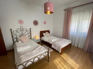 索布拉尔德蒙特阿格拉苏Quinta do Carvalheiro的一间卧室设有两张床、一个窗口和一盏灯。