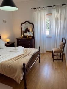 索布拉尔德蒙特阿格拉苏Quinta do Carvalheiro的卧室配有床、椅子和窗户。