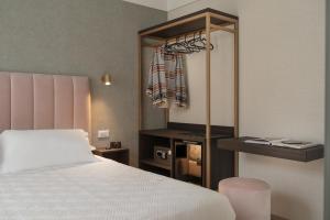 里乔内Hotel Sole的卧室配有白色的床和衣柜。