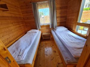 里沃Domki Gościniak的木间设有两张床,配有两扇窗户