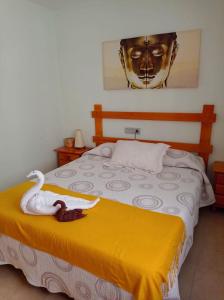 卡沃内拉斯Luz de Mar.的一间卧室配有一张带天鹅的床