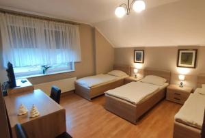 NiewierzNoclegi u Maxa的酒店客房设有两张床和一张桌子。