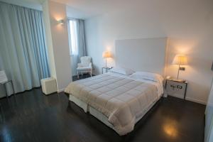 圣马力诺Hotel iDesign的一间卧室配有一张大床和一把椅子