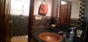 依索安Mubaradise Surf Hostel的浴室设有棕色水槽和镜子