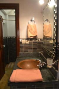 依索安Mubaradise Surf Hostel的浴室设有棕色水槽和镜子