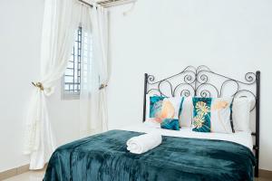 杜阿拉L'IMMEUBLE QUEEN M.N.M的白色卧室配有一张带绿毯的大床