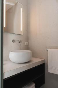 里乔内Hotel Sole的浴室设有白色水槽和镜子