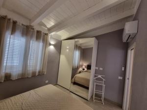 罗萨岛Appartamento Spargi的一间小卧室,配有一张床和镜子