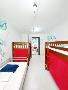 圣克鲁斯-德特内里费特内里费之旅旅馆的一间设有两张红色和蓝色床单的房间