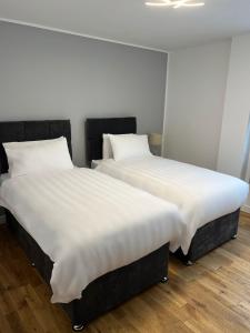 因弗内斯Inverness Highland Apartment的两张睡床彼此相邻,位于一个房间里