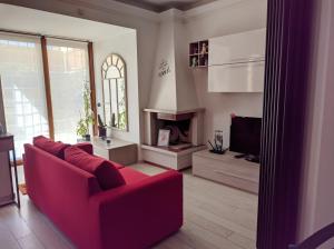 罗马La casetta gialla的客厅设有红色的沙发和壁炉