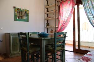 圣特雷莎加卢拉Charming flat in Santa Teresa Gallura的窗户客房内的桌椅