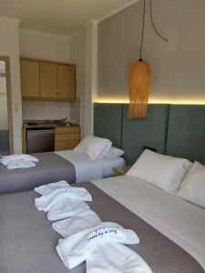 罗达Ninos On The Beach Hotel的两张位于酒店客房的床,配有毛巾
