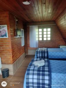 阿尤鲁奥卡Pousada nossa senhora的小木屋内一间卧室,配有两张床