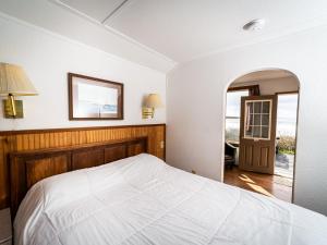 欧申赛德Oceanside Ocean Front Cabins的卧室配有白色的床和镜子