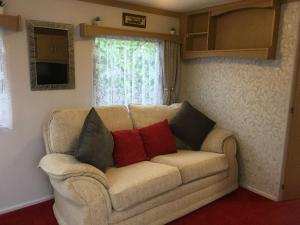 海尔The Caravan at Loggans Lodge的客厅配有带4个枕头的沙发