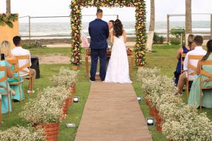 卡博迪圣阿戈斯蒂尼奥EnseadaPrime eventos e casamentos beira-mar na Praia Enseada dos Corais em PE的婚礼上,新娘和新郎在过道上走下走
