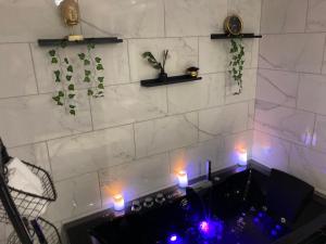 克雷伊Séduisant petit cocon的浴室配有带蜡烛的浴缸。