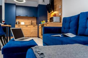 比得哥什Premium Wrocławska Apartament Parking的客厅里一张蓝色沙发上的笔记本电脑