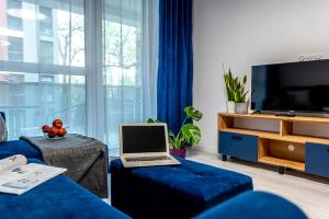 比得哥什Premium Wrocławska Apartament Parking的客厅配有蓝沙发上的笔记本电脑