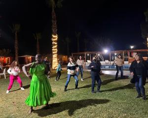 上钦查La Estancia Chincha Hotel的一群人晚上在草地上跳舞
