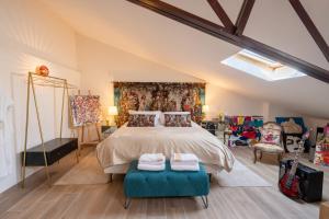 阿维尼翁L’Avant Scène - Loft de Luxe - Atelier d'artiste的一间卧室配有一张大床和两张蓝色的奥托曼斯