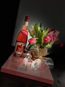 瓦特拉多尔内Casa Lupascu的一瓶葡萄酒和一本书上装有鲜花的花瓶