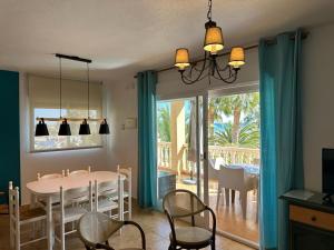 博尔钮乌绿洲拉斯棕榈公寓的一间带桌椅和窗户的用餐室