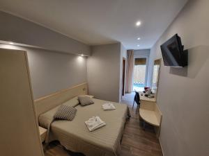 布雷佐内加尔达Hotel Garni Rosmari的客房设有两张床、一张桌子和一台电视。