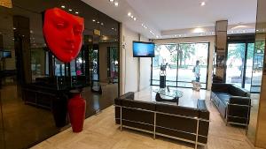 科连特斯Corrientes Plaza Hotel的一间在房间里展示红色花瓶的商店