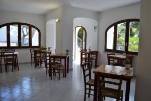 伊斯基亚Cocos Park Ischia的餐厅设有木桌、椅子和窗户。