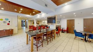 伯灵顿南伯灵顿快捷假日酒店的用餐室配有桌椅和平面电视。