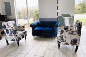 布兰森Capital O - Classic Motor Inn Branson的客房内的蓝色沙发和两把椅子
