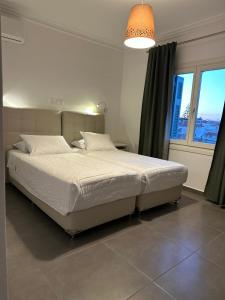 斯派赛斯Kamelia Hotel的卧室配有一张大白色床和窗户