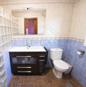 加的斯Villa Zahara de 3 habitaciones con Piscina的一间带卫生间、水槽和镜子的浴室