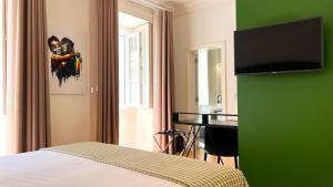 里斯本Jardim da Lapa by Shiadu的一间卧室配有一张床和一张书桌,并拥有绿色的墙壁