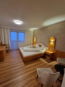 耶岑斯Hotel Garni Romantica的酒店客房,配有一张床、一张桌子和椅子