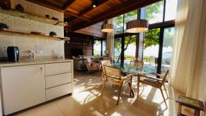 蜜岛Ilha do Mel Lodges的厨房以及带玻璃桌和椅子的用餐室