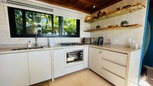 蜜岛Ilha do Mel Lodges的厨房配有白色橱柜和炉灶烤箱。