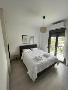 雅典Tiffany's apartments -2' walk from Metro的白色卧室配有一张大床和两条毛巾