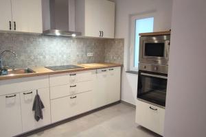沙勒罗瓦L'escale tout confort的厨房配有白色橱柜、水槽和微波炉