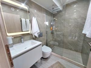 海若克利欧MAXIM APARTMENT的带淋浴、盥洗盆和卫生间的浴室